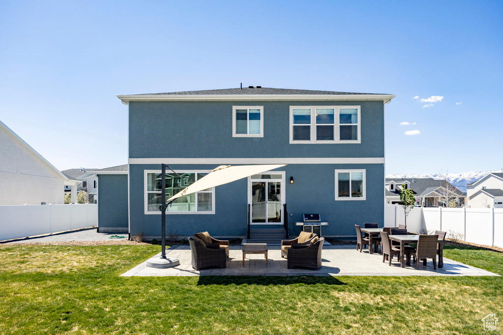 Back of property with an outdoor hangout area, a patio area, and stucco siding