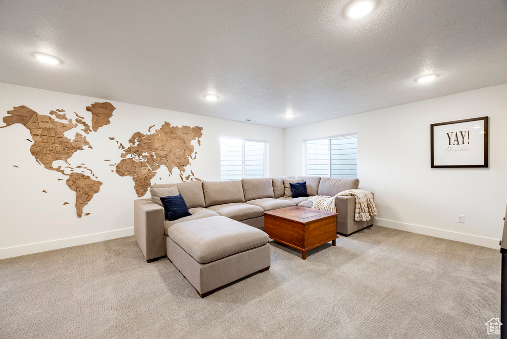 Living room with baseboards, light carpet, recessed lighting, and a textured ceiling