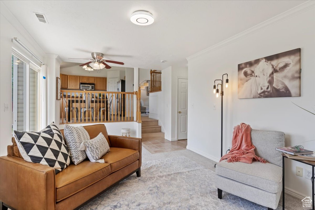 Living room with ceiling fan, stairway, ornamental molding, and baseboards