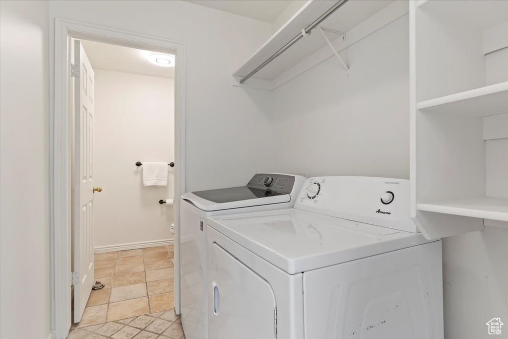 Clothes washing area featuring washing machine and dryer and baseboards
