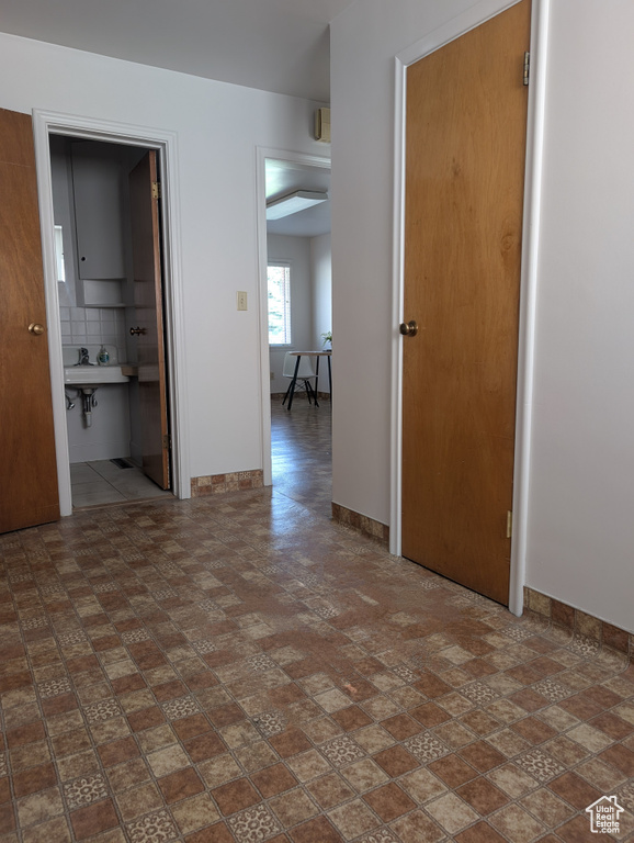 Spare room with baseboards and a sink