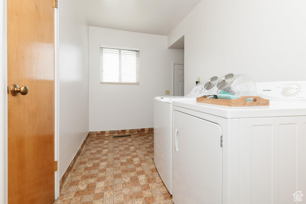 Laundry room featuring baseboards, light floors, laundry area, and washer and dryer