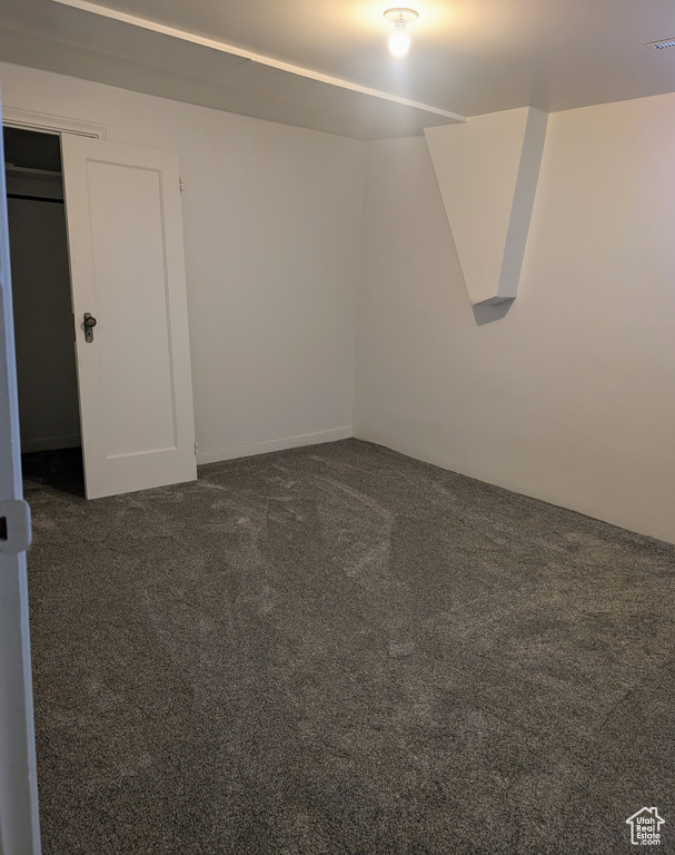 Empty room with dark colored carpet