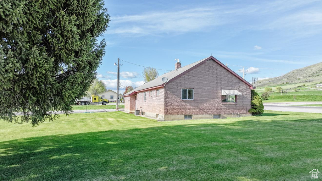 View of home\\\\\\\\\\\\\\\\\\\\\\\\\\\\\\\\\\\\\\\\\\\\\\\\\\\\\\\\\\\\\\\'s exterior with a yard, a chimney, central air condition unit, and brick siding