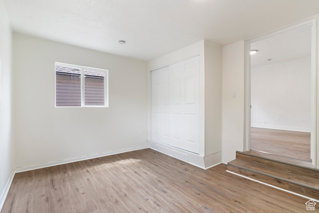 Unfurnished bedroom featuring a closet, baseboards, and wood finished floors