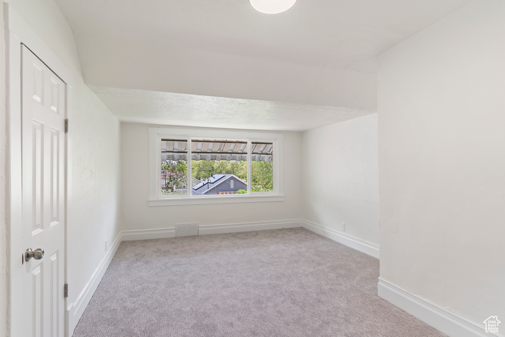 Empty room featuring visible vents, baseboards, and carpet floors