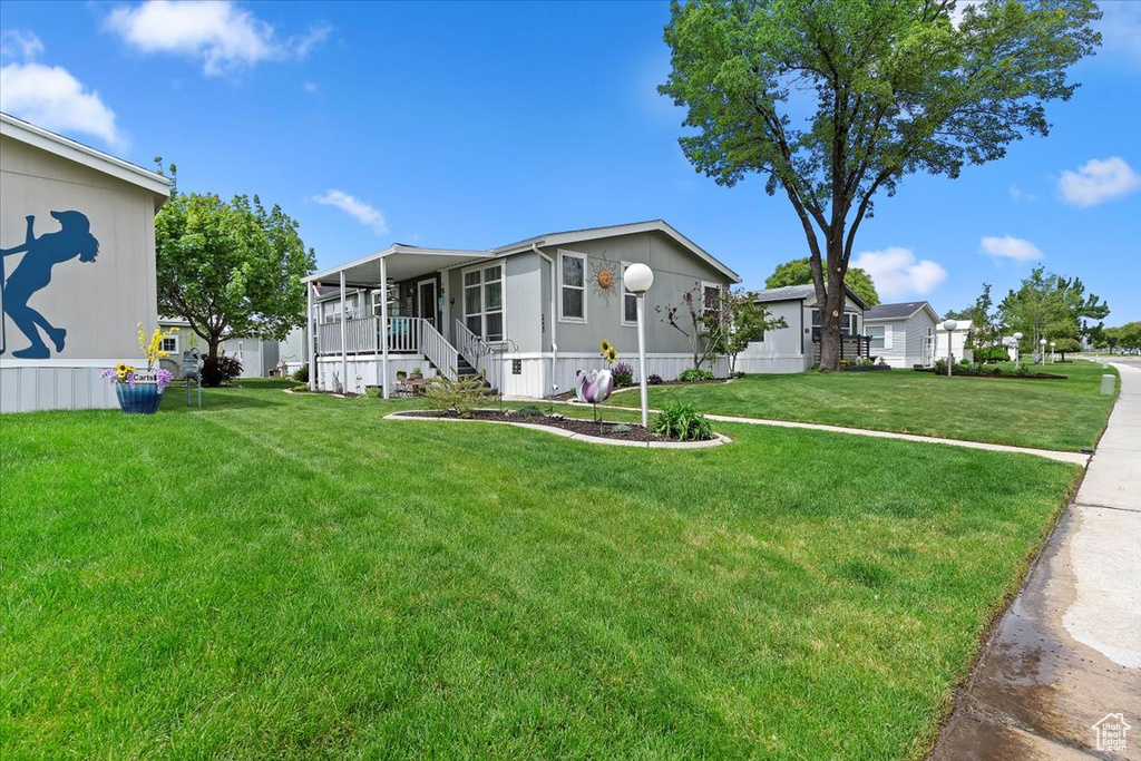 Manufactured / mobile home featuring a sunroom and a front lawn