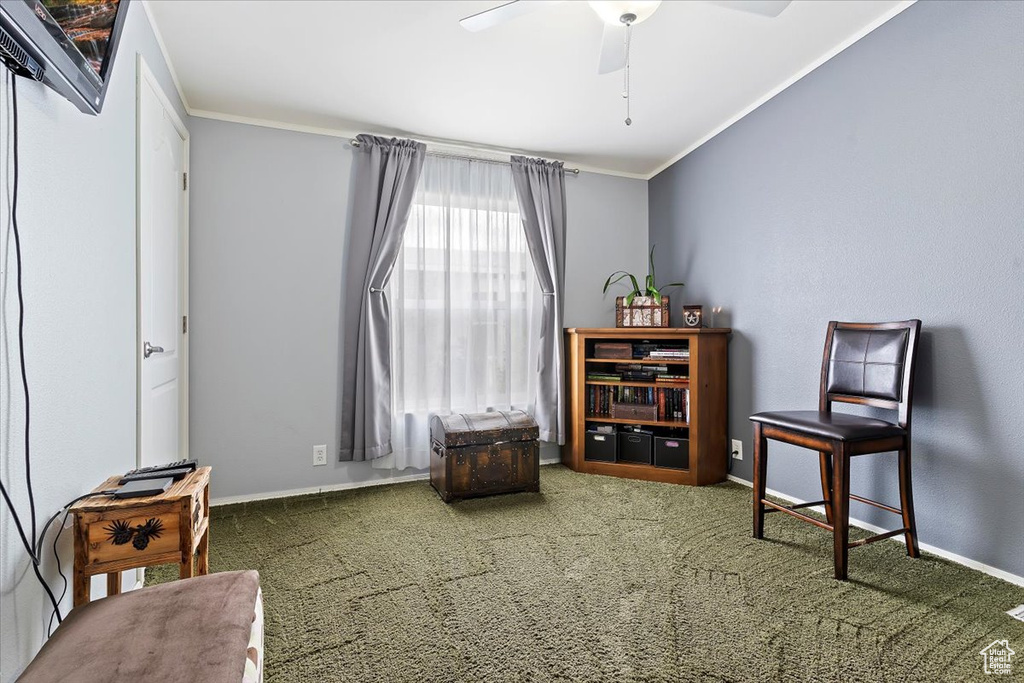 Living area featuring ornamental molding, carpet, baseboards, and a ceiling fan