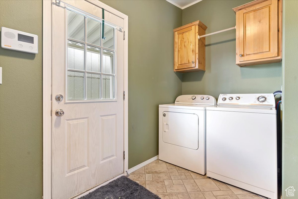 Laundry room with baseboards, independent washer and dryer, and cabinet space