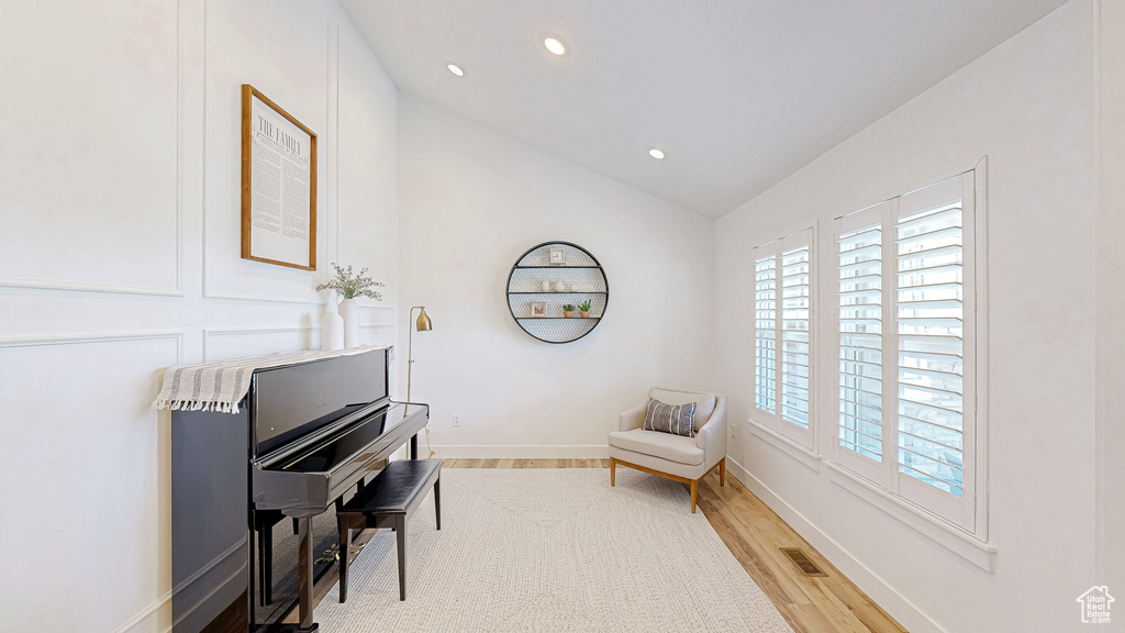 Living area with recessed lighting, lofted ceiling, light wood-style flooring, and baseboards