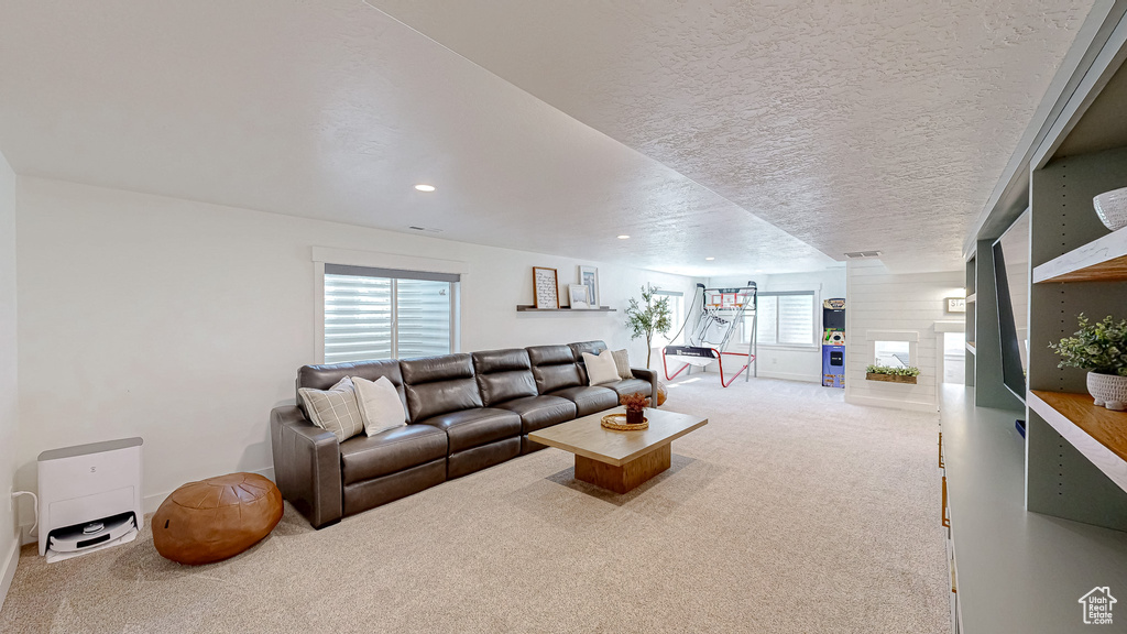 Carpeted living area with recessed lighting and a fireplace