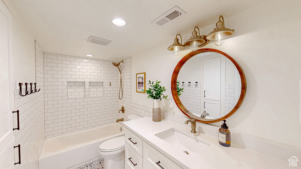 Bathroom with toilet, recessed lighting, vanity, and washtub / shower combination