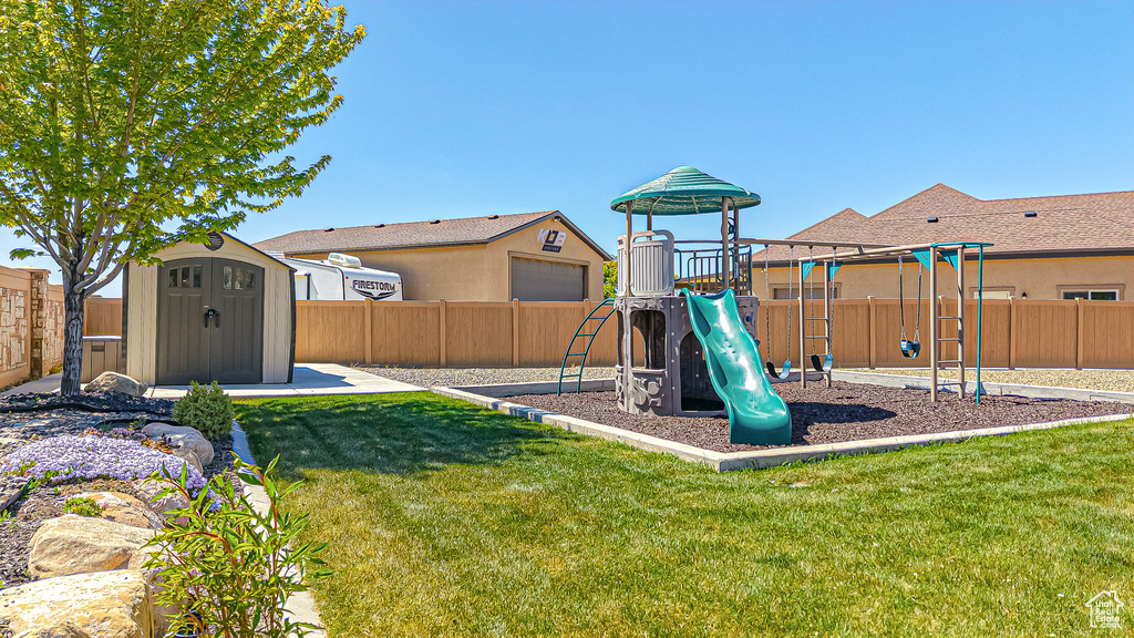 View of jungle gym featuring a storage unit and an outdoor structure