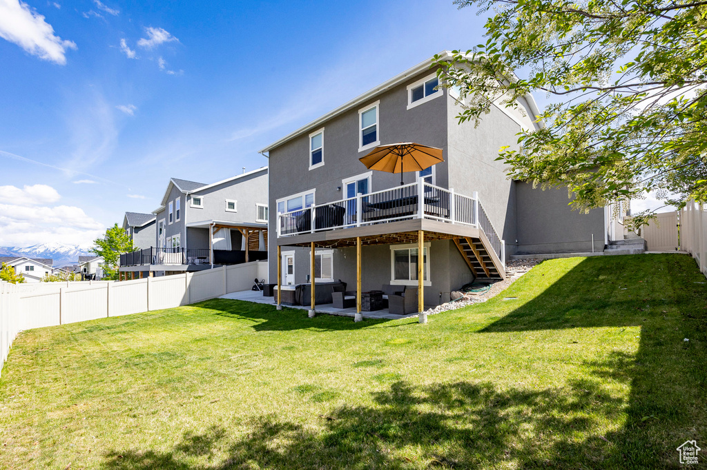 Back of house with outdoor lounge area, stucco siding, a wooden deck, stairs, and a patio area