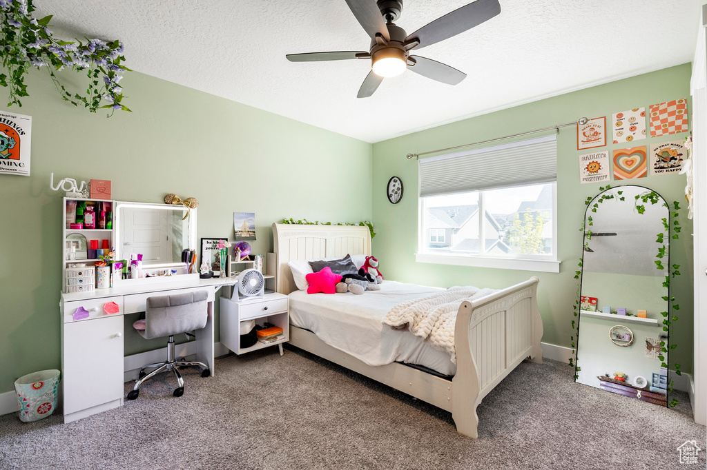 Bedroom featuring carpet, a ceiling fan, and a textured ceiling