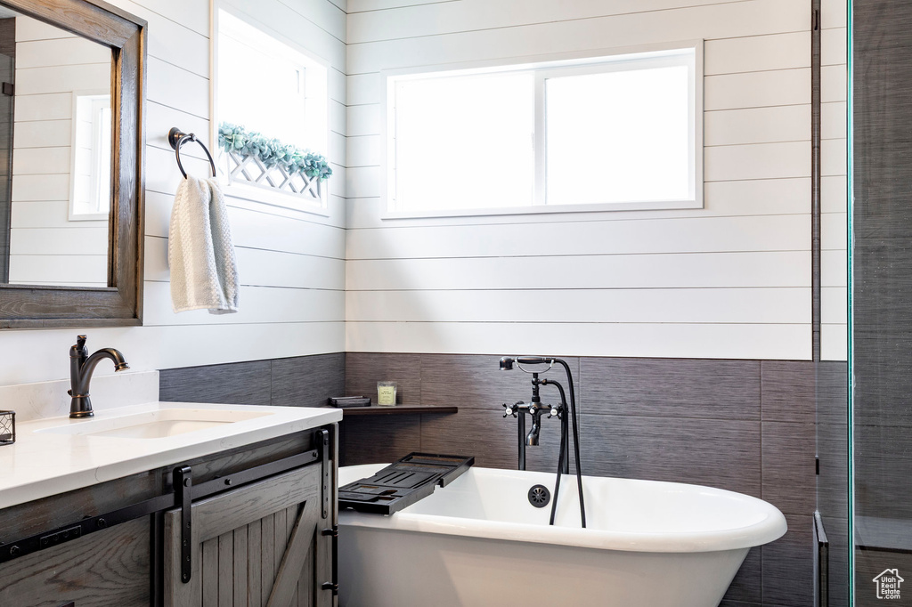Full bath featuring vanity and a freestanding bath
