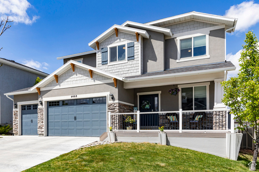 Craftsman house featuring a porch, driveway, stone siding, a garage, and stucco siding