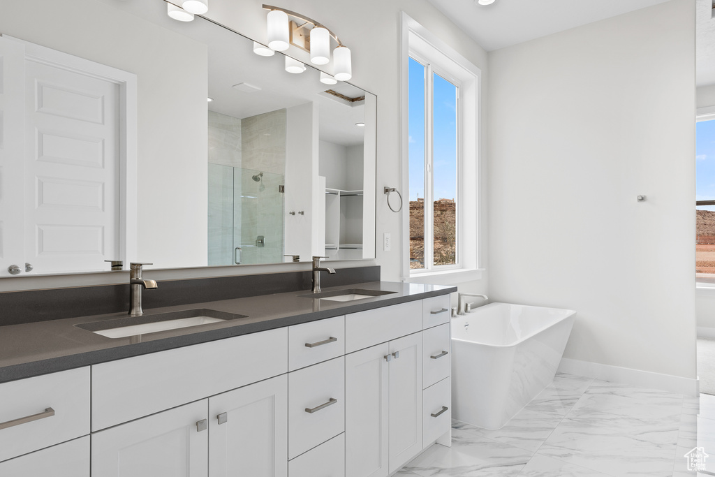 Full bath with a stall shower, healthy amount of natural light, marble look tile flooring, and baseboards