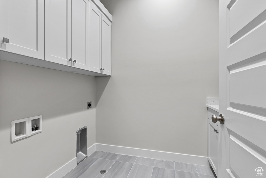Laundry room with cabinet space, washer hookup, hookup for an electric dryer, and baseboards