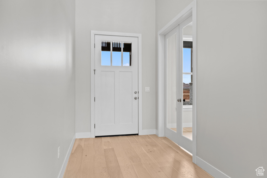 Doorway featuring light wood-style flooring and baseboards