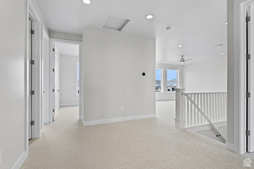 Corridor featuring an upstairs landing, light carpet, recessed lighting, baseboards, and attic access