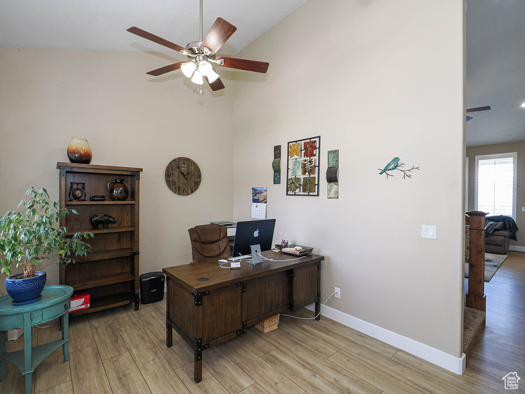 Office with ceiling fan, light wood-style flooring, baseboards, and high vaulted ceiling