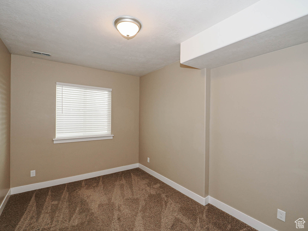 Carpeted empty room featuring baseboards