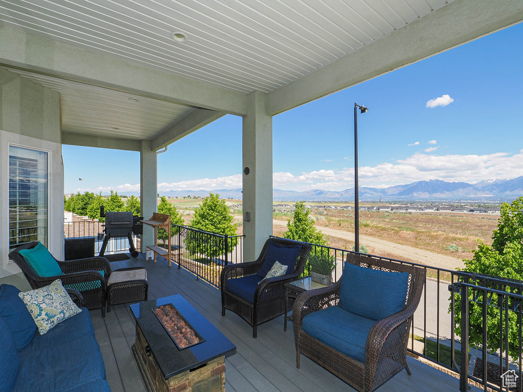 Wooden deck with an outdoor living space with a fire pit and a mountain view