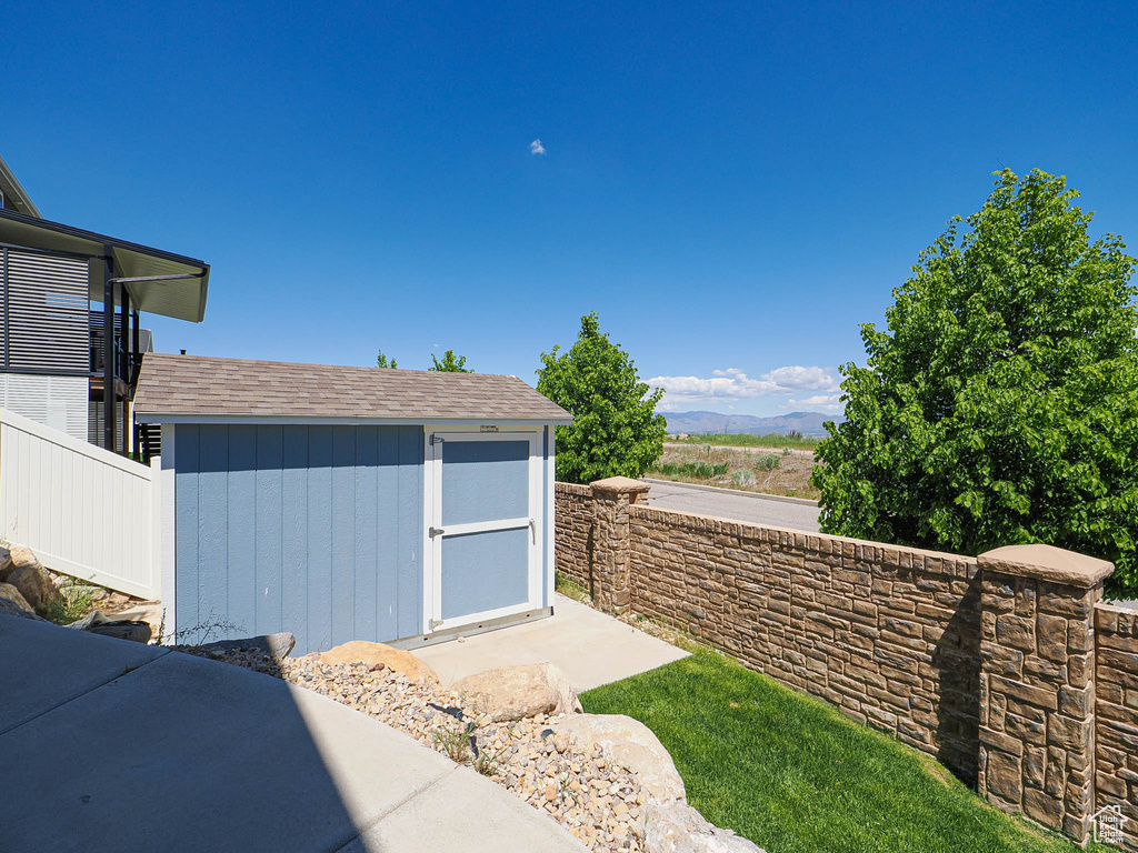 View of shed featuring fence and a mountain view