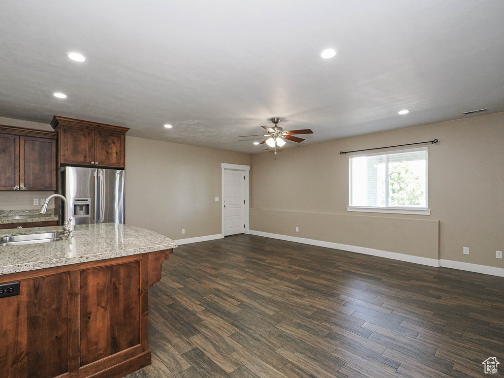 Kitchen with stainless steel fridge, a sink, ceiling fan, baseboards, and recessed lighting