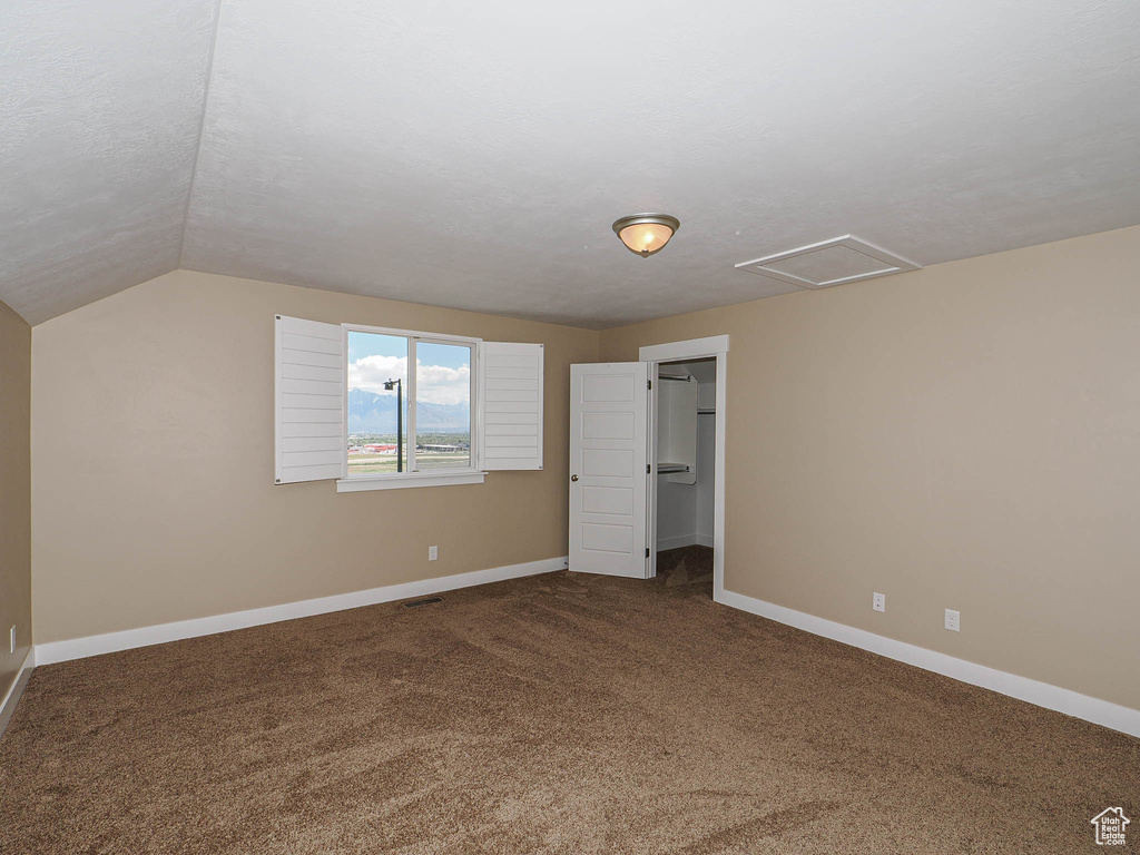 Additional living space with carpet, baseboards, vaulted ceiling, and attic access