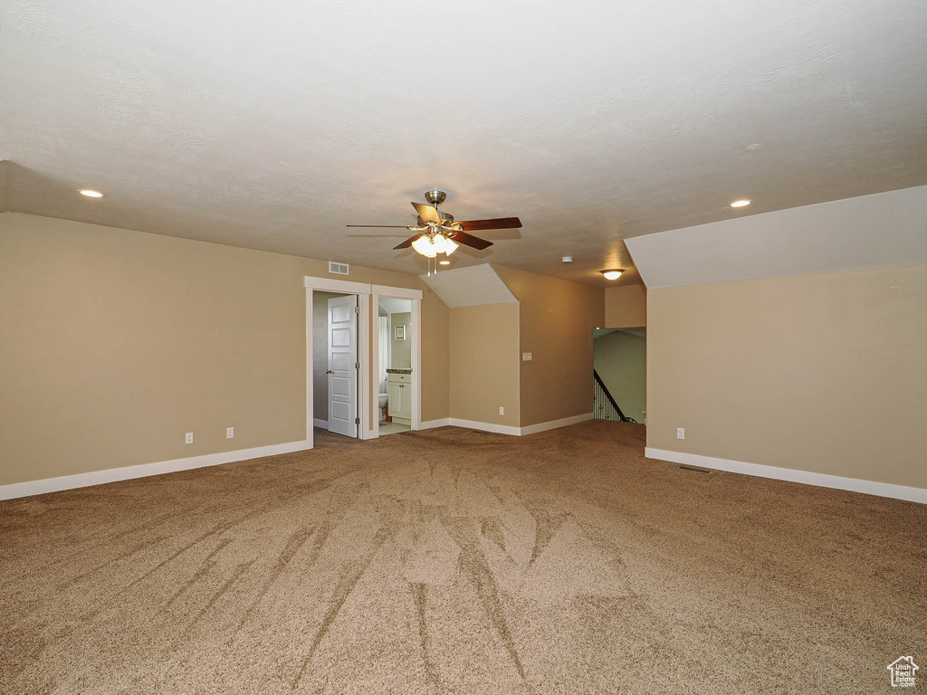 Spare room featuring carpet flooring, ceiling fan, baseboards, recessed lighting, and vaulted ceiling