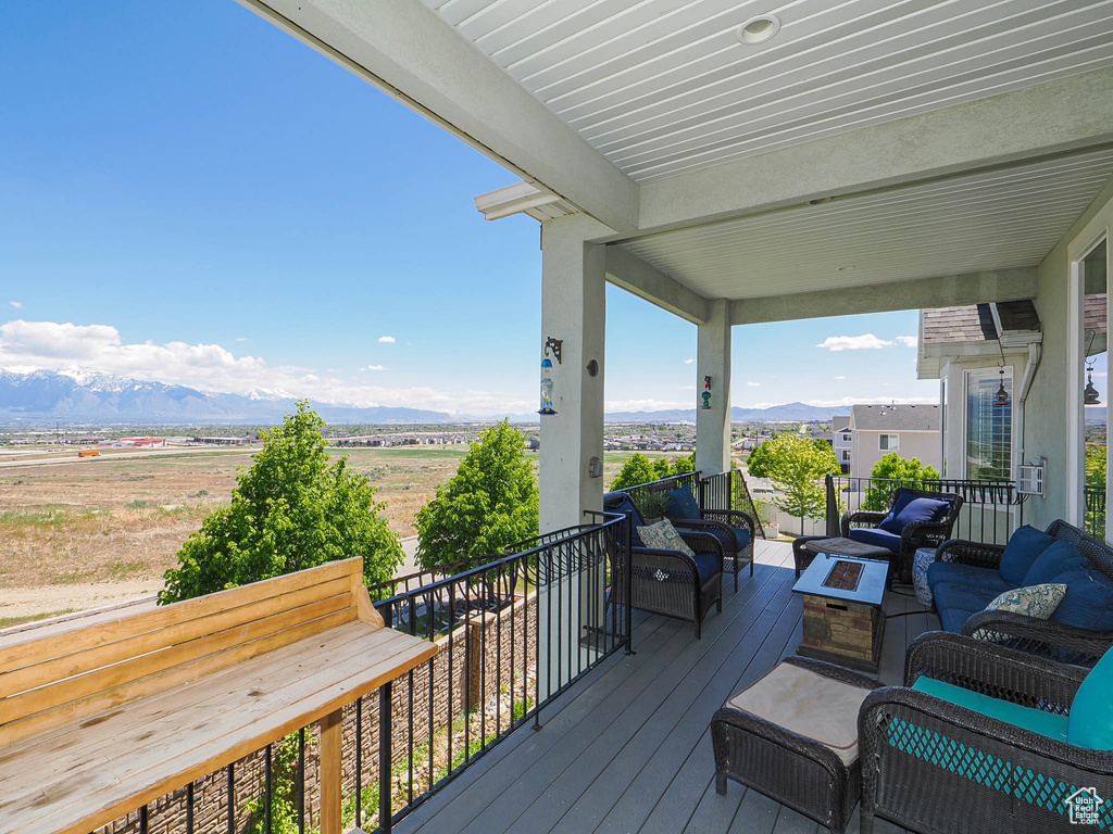 Deck featuring an outdoor living space with a fire pit and a mountain view