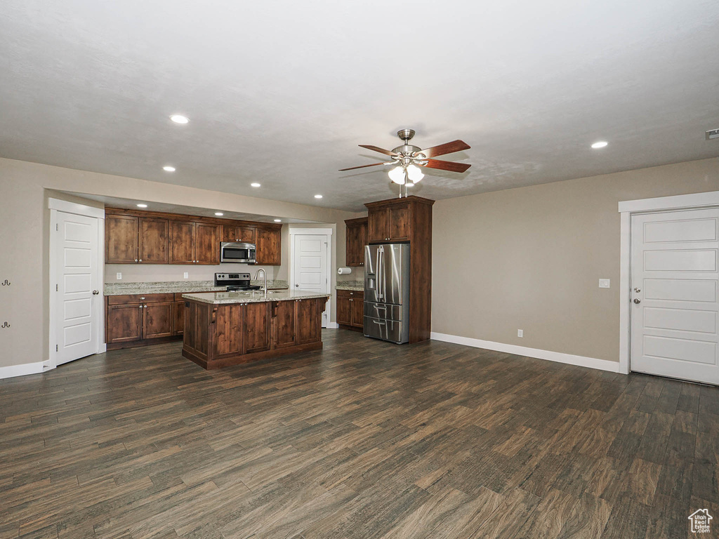 Kitchen featuring stainless steel appliances, recessed lighting, ceiling fan, baseboards, and dark wood-style floors