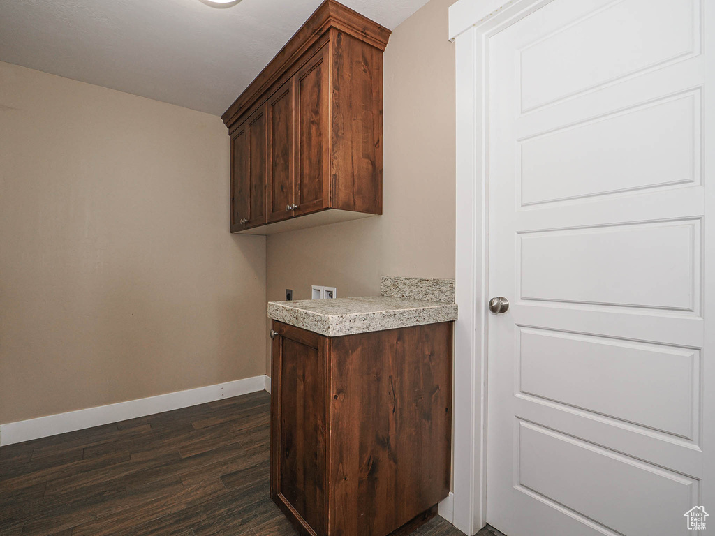 Laundry area with dark wood-style floors, cabinet space, baseboards, and hookup for a washing machine