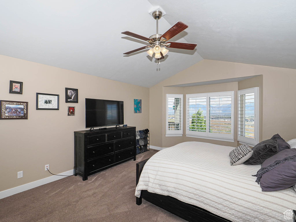 Bedroom featuring carpet flooring, baseboards, vaulted ceiling, and a ceiling fan