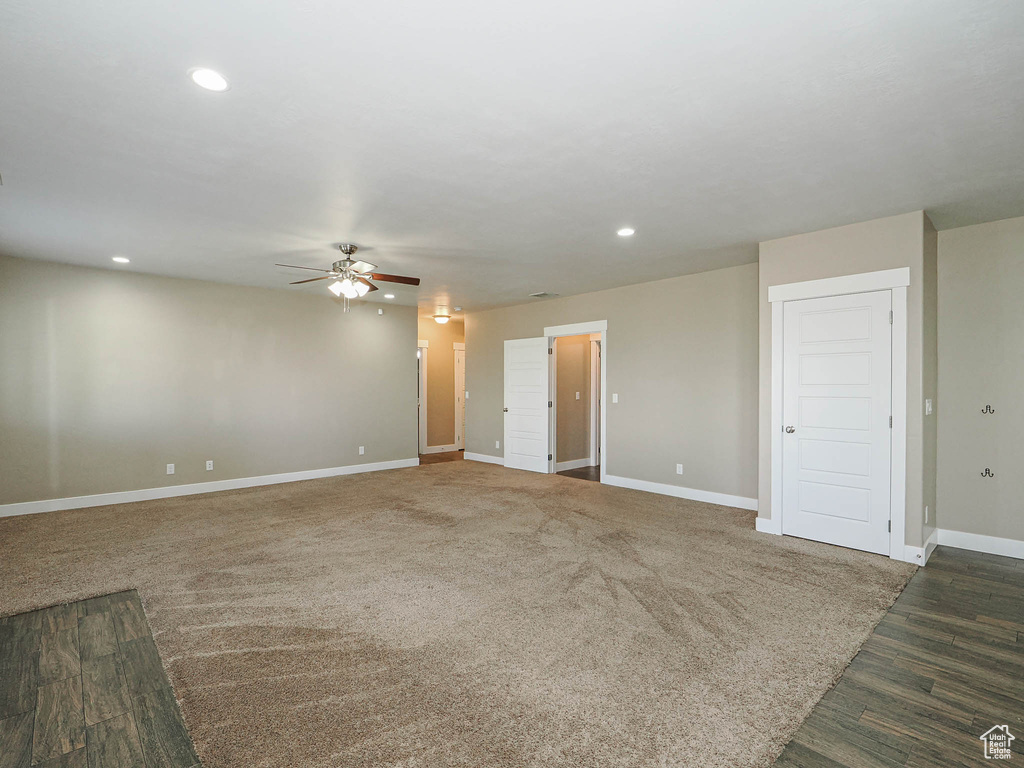 Unfurnished living room featuring a ceiling fan, recessed lighting, baseboards, and wood finished floors