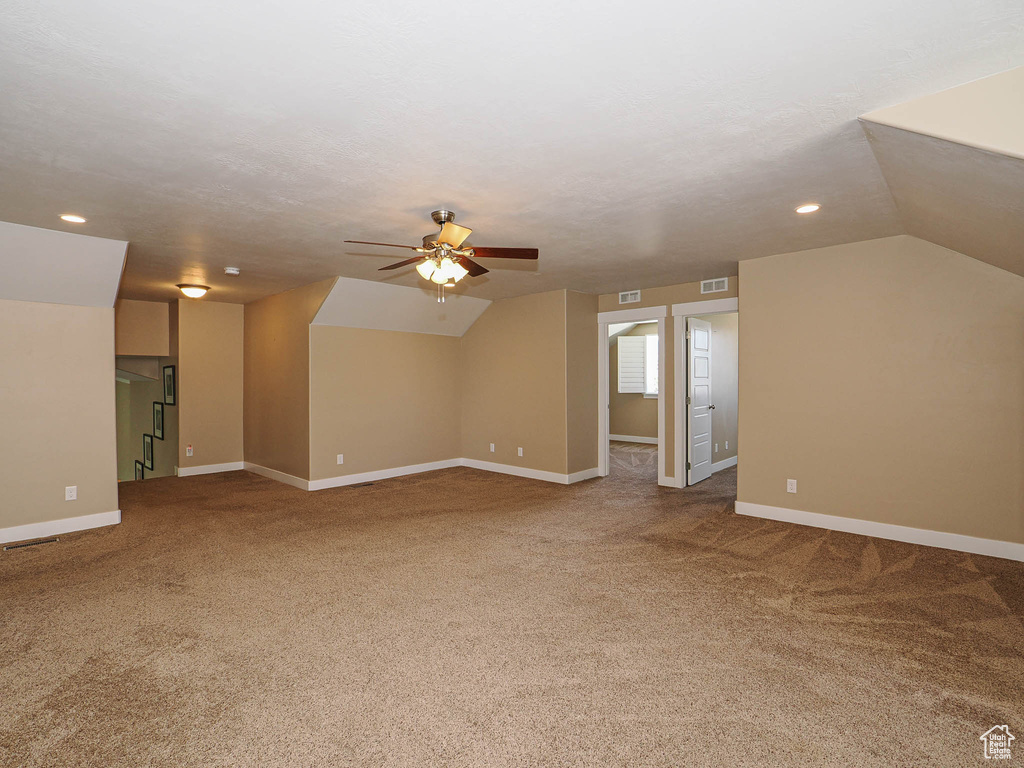 Additional living space featuring carpet flooring, ceiling fan, baseboards, vaulted ceiling, and recessed lighting