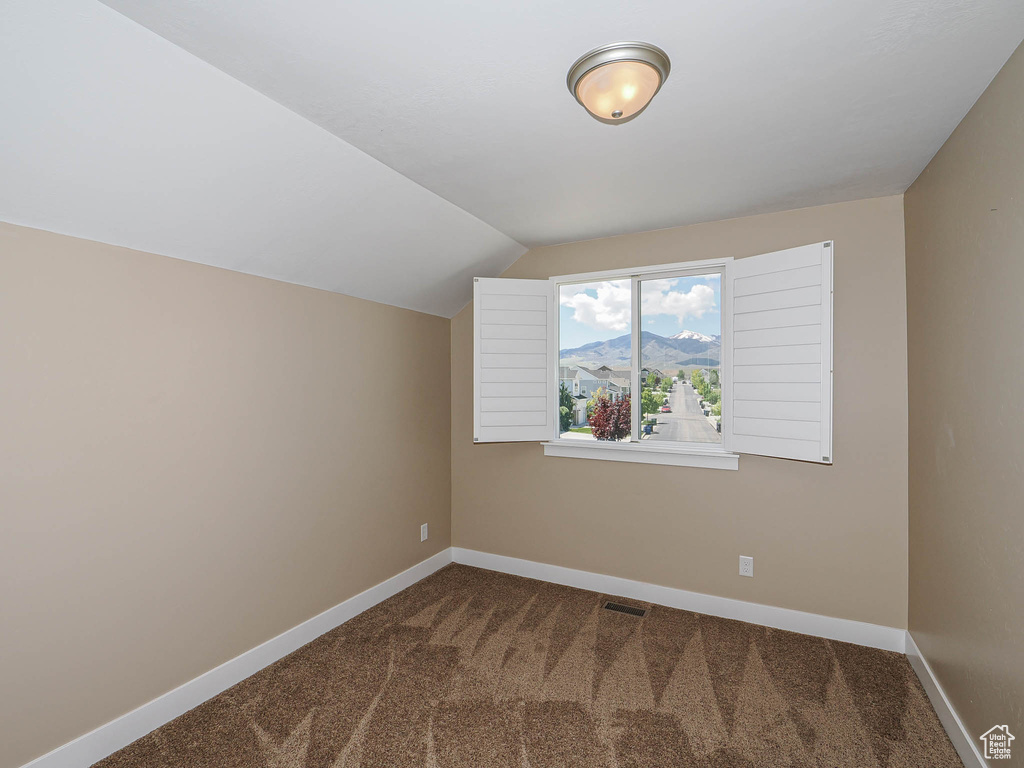 Additional living space with carpet, vaulted ceiling, baseboards, and a mountain view