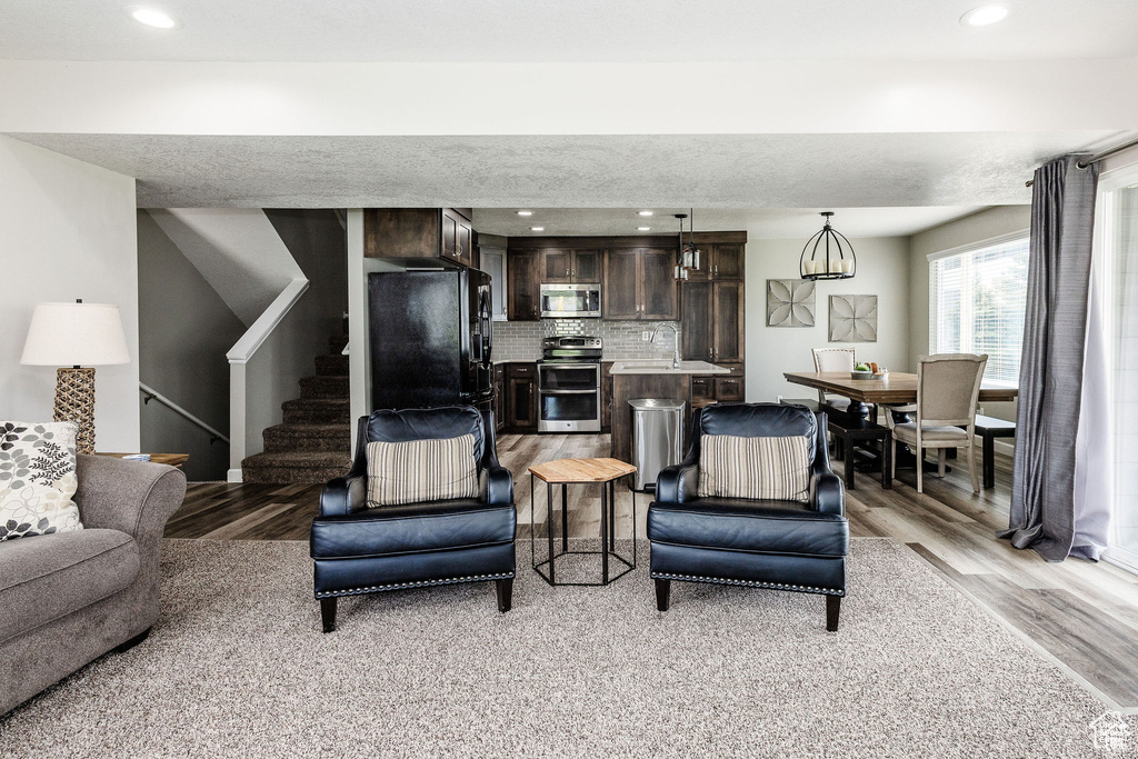 Living area with light wood-style floors, stairs, and recessed lighting