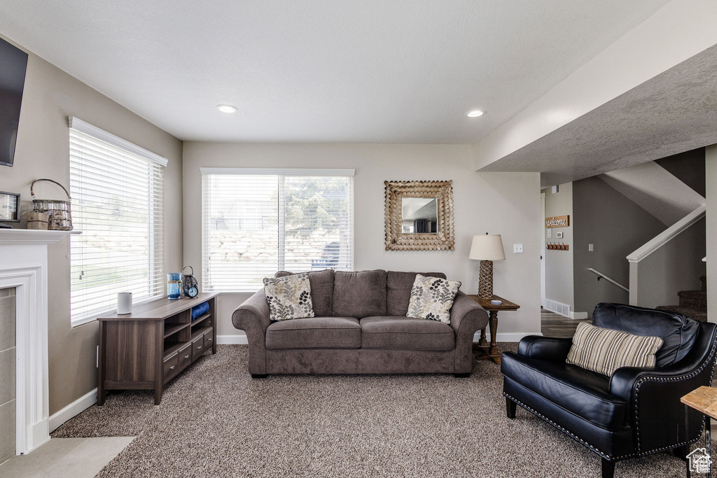 Living room featuring light colored carpet, baseboards, stairs, and recessed lighting