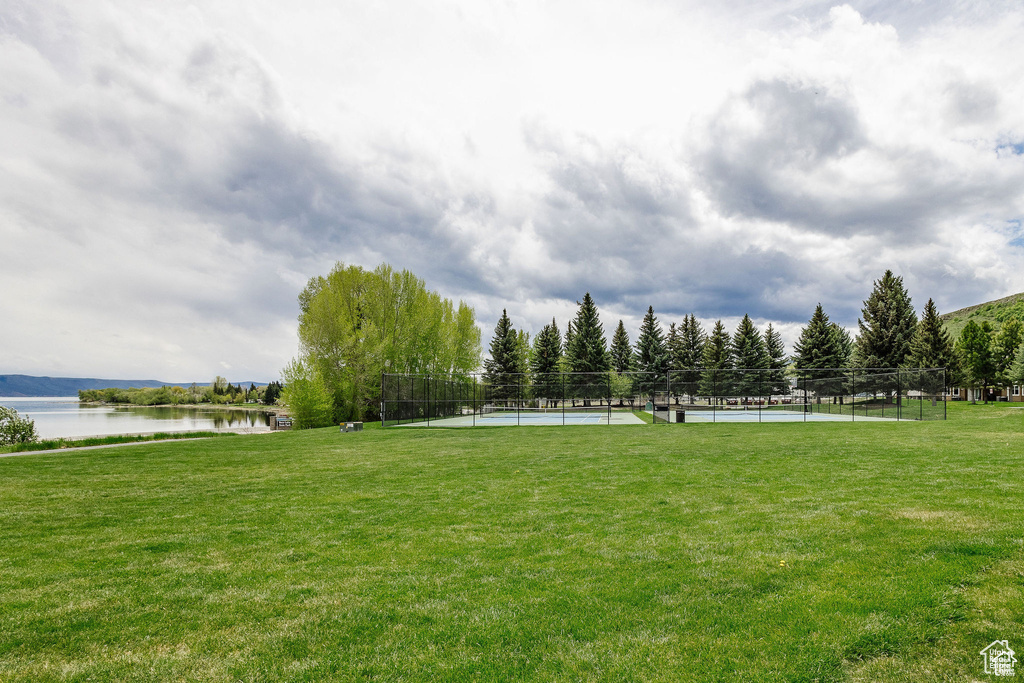 View of property's community with a tennis court and a water view