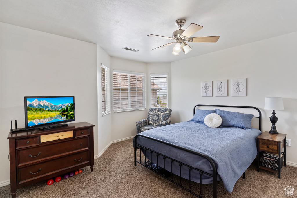 Carpeted bedroom featuring baseboards and ceiling fan