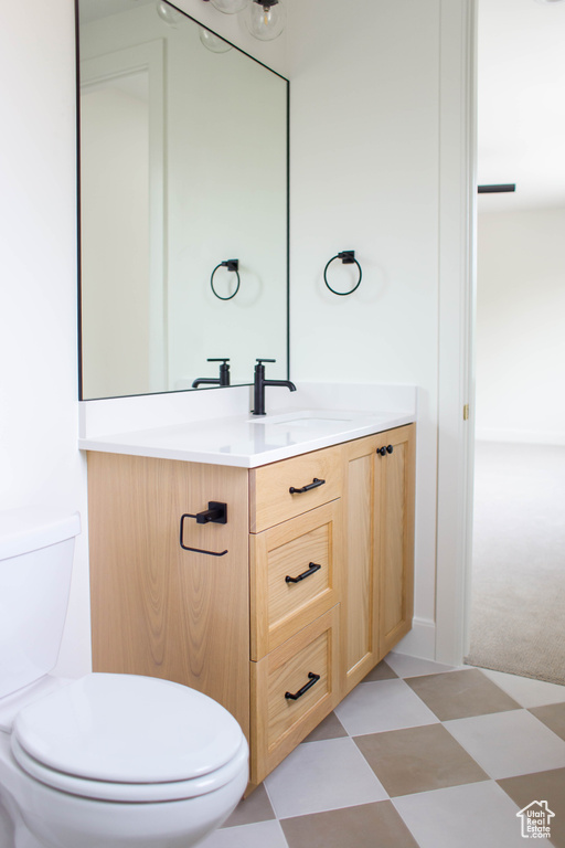 Bathroom with vanity, toilet, and tile patterned floors