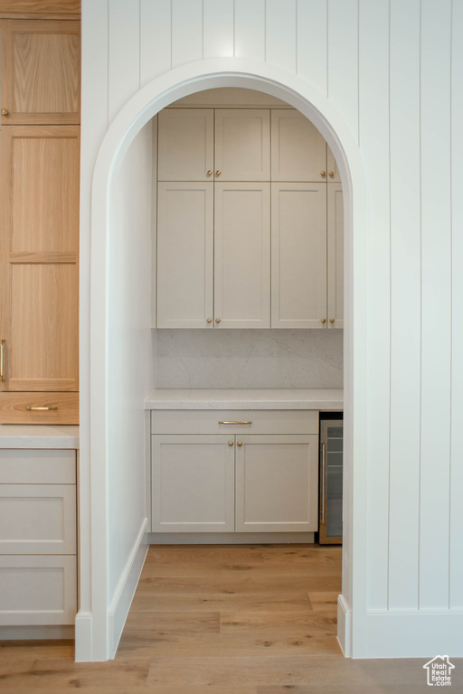 Interior space featuring wood finished floors, arched walkways, and wine cooler