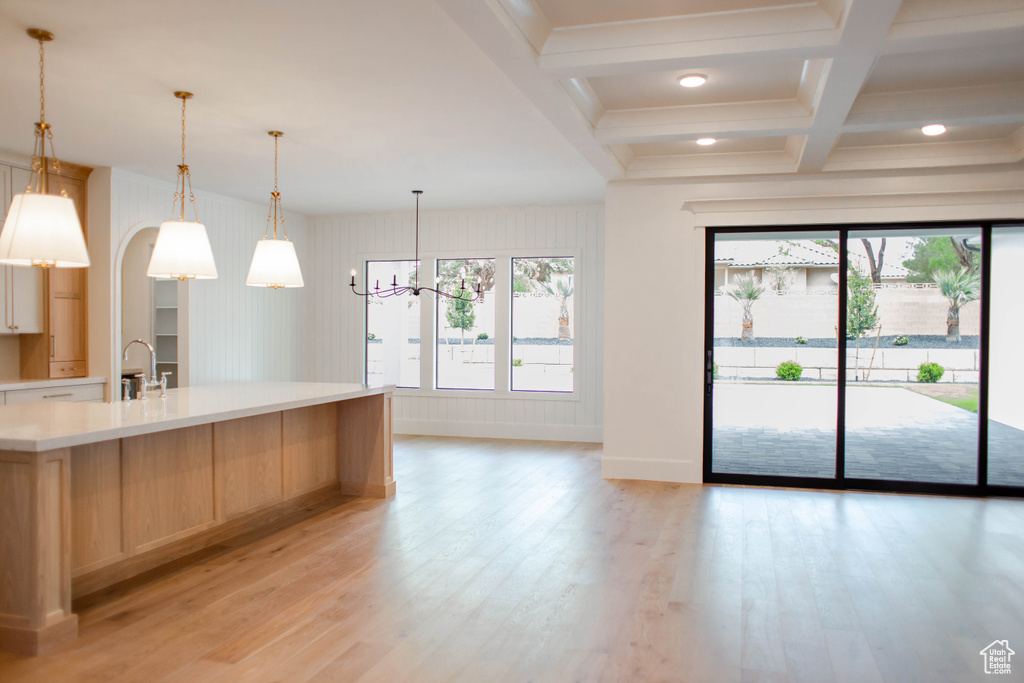 Kitchen featuring a chandelier, light brown cabinetry, plenty of natural light, and light wood-style floors