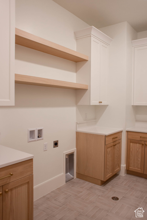 Washroom with cabinet space, washer hookup, baseboards, and hookup for an electric dryer