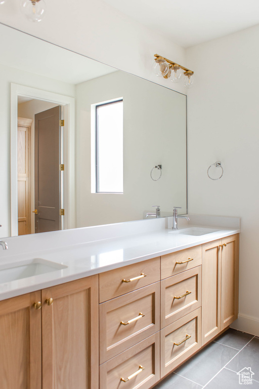 Full bath featuring tile patterned floors, double vanity, and a sink