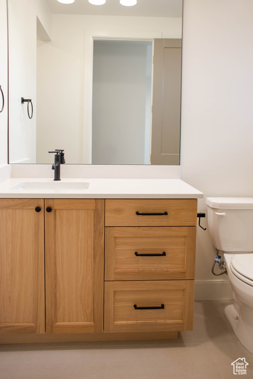 Bathroom with tile patterned floors, toilet, baseboards, and vanity