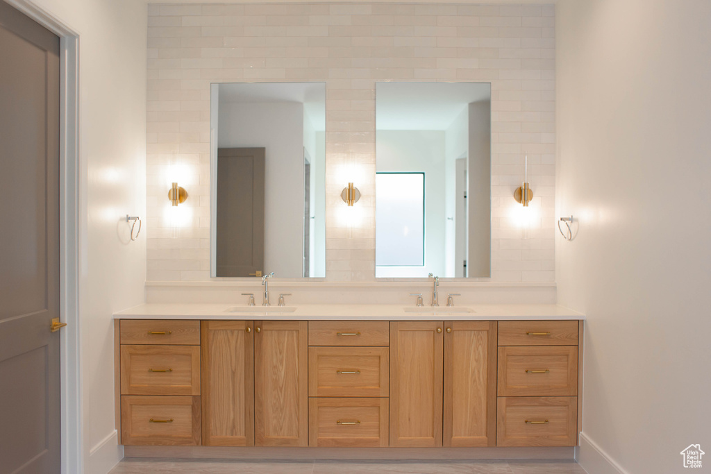 Bathroom featuring a sink, double vanity, and baseboards